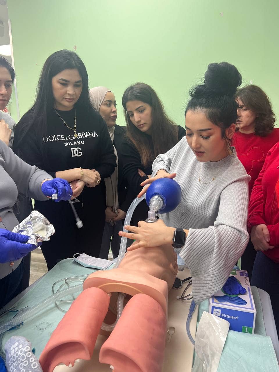Students in an NCLEX prep class practicing with a bag-valve mask on a training mannequin